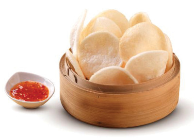 Bamboo steamer basket filled with shrimp chips and Thai dipping sauce.